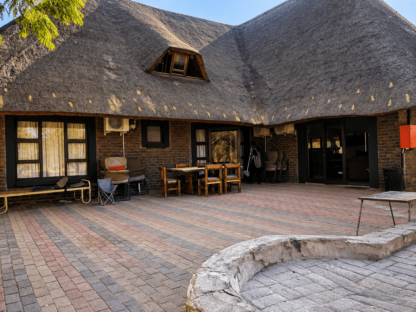 Thatched lodge building and paved patio at Bougasvlei Safaris, Thabazimbi