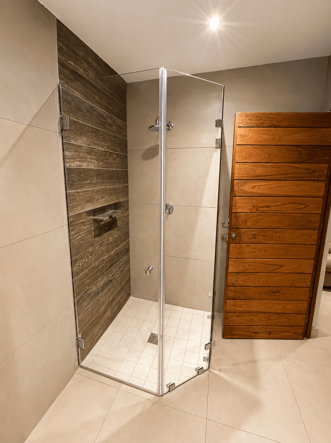 Modern walk-in glass shower with wood-feature tiling at the Bougasvlei lodge
